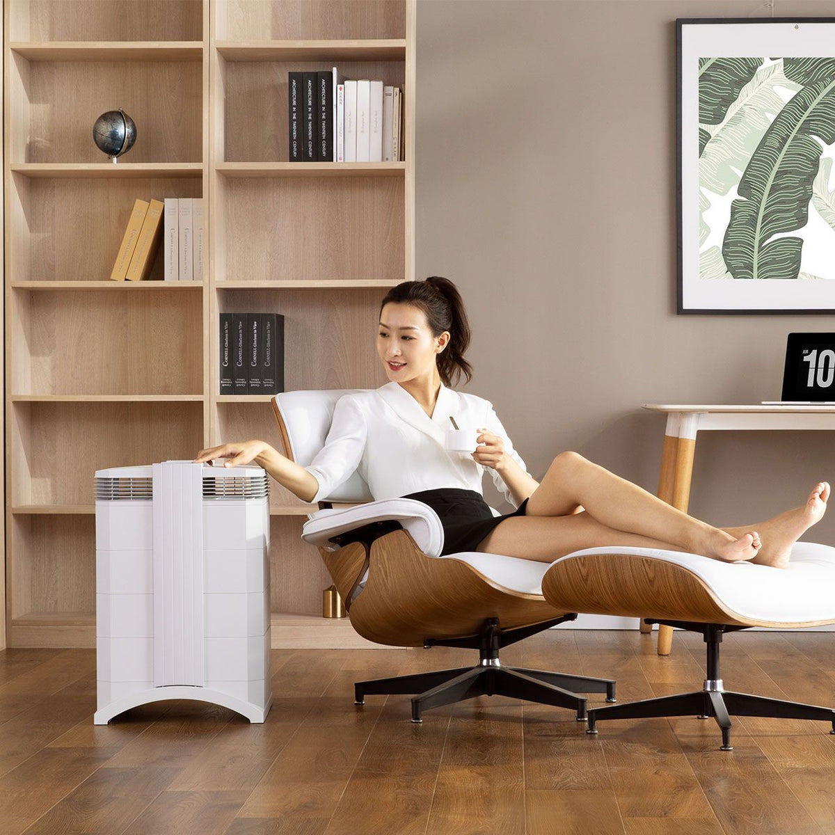 IQAir HealthPro 100 XE Luftreiniger in Weiß neben Loungesessel im Wohnzimmer
