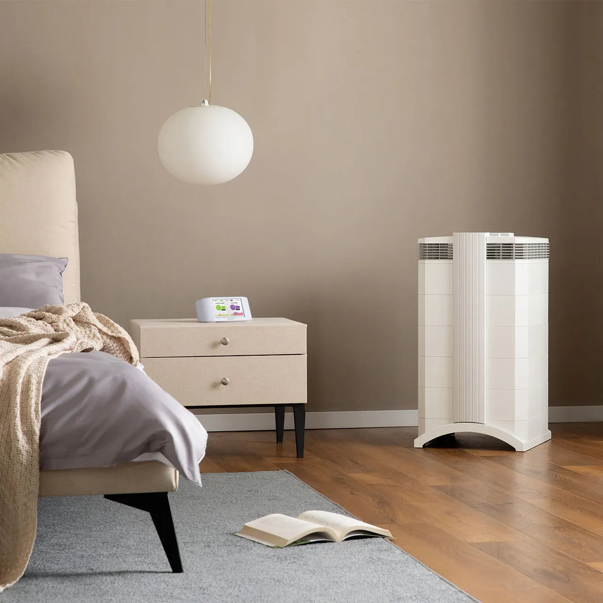 IQAir HealthPro 250 XE Luftreiniger in Weiß, stehend neben Nachttisch im Schlafzimmer