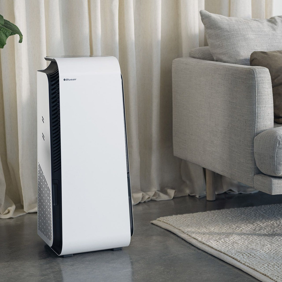 Blueair HealthProtect 7440i Luftreiniger in Weiß neben Sofa im Wohnzimmer