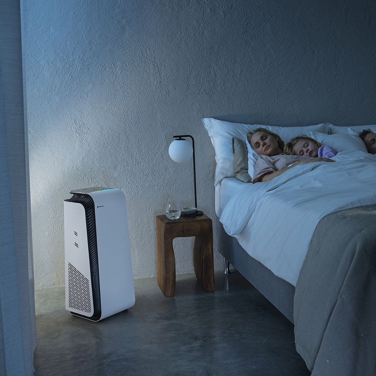 Blueair HealthProtect 7440i Luftreiniger im Schlafzimmer neben Bett mit schlafender Familie