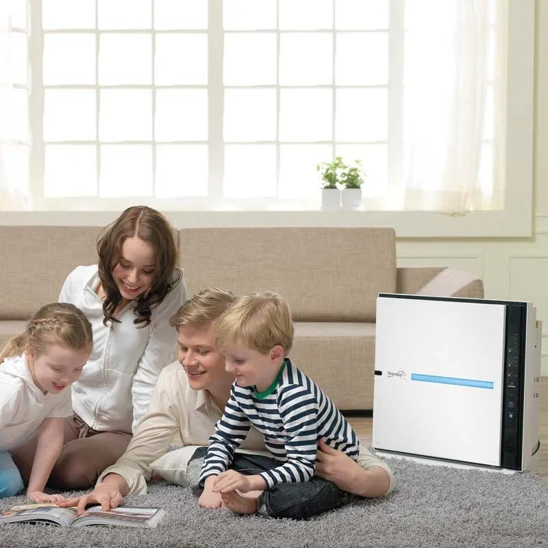 Familie mit zwei Kindern sitzt im Wohnzimmer neben dem Zepter Therapy Air iON Luftreiniger