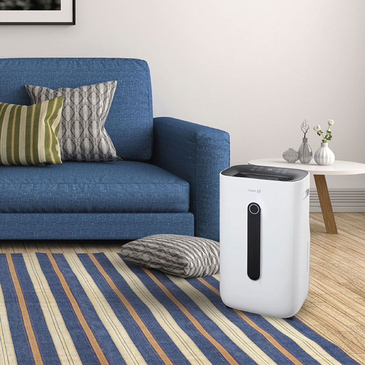 Clean Air Optima CA-706 Smart Luftentfeuchter in weiß neben blauem Sofa im Wohnzimmer