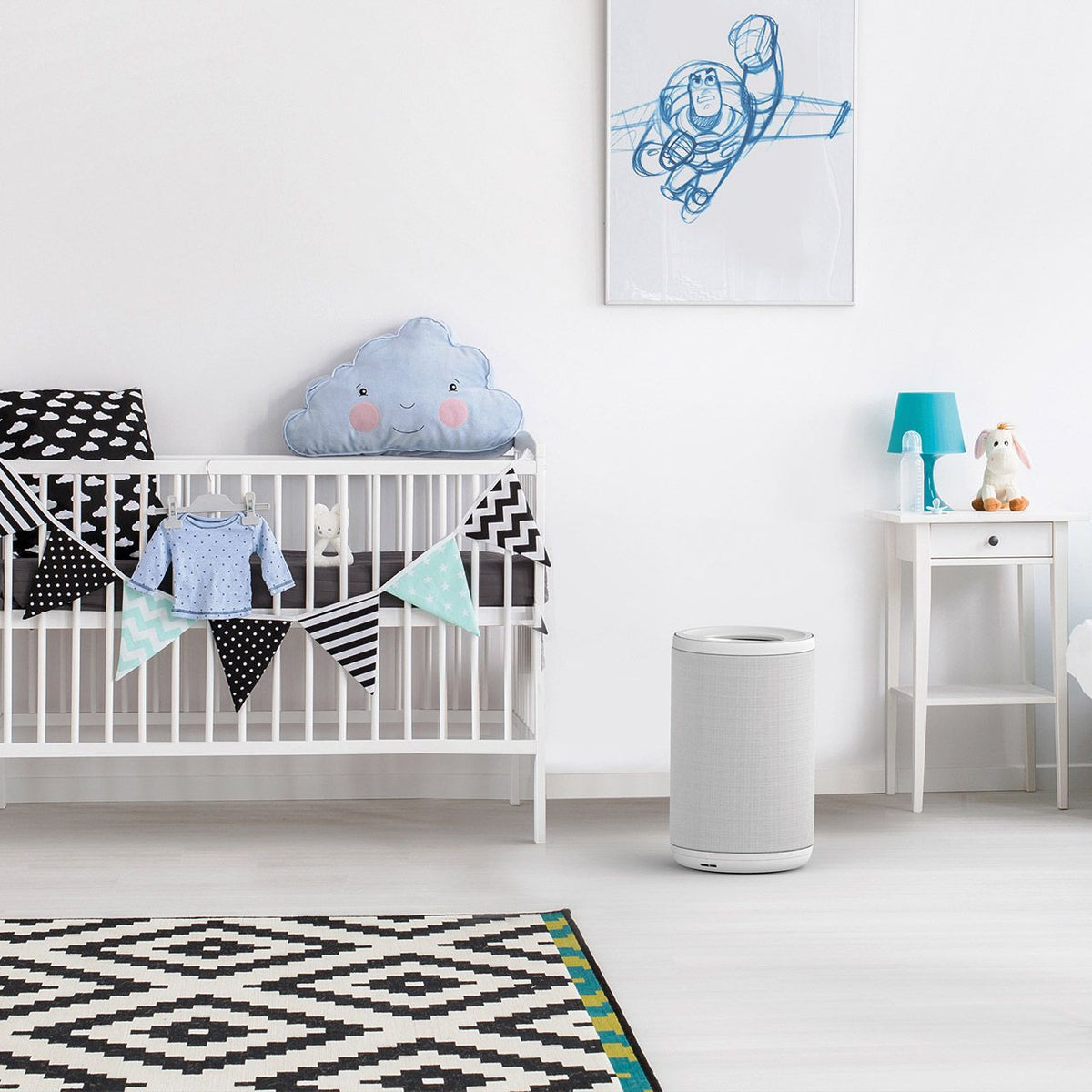 Aeris aair LITE Luftreiniger in Grau neben Wickelkommode im Babyzimmer mit Kinderbett