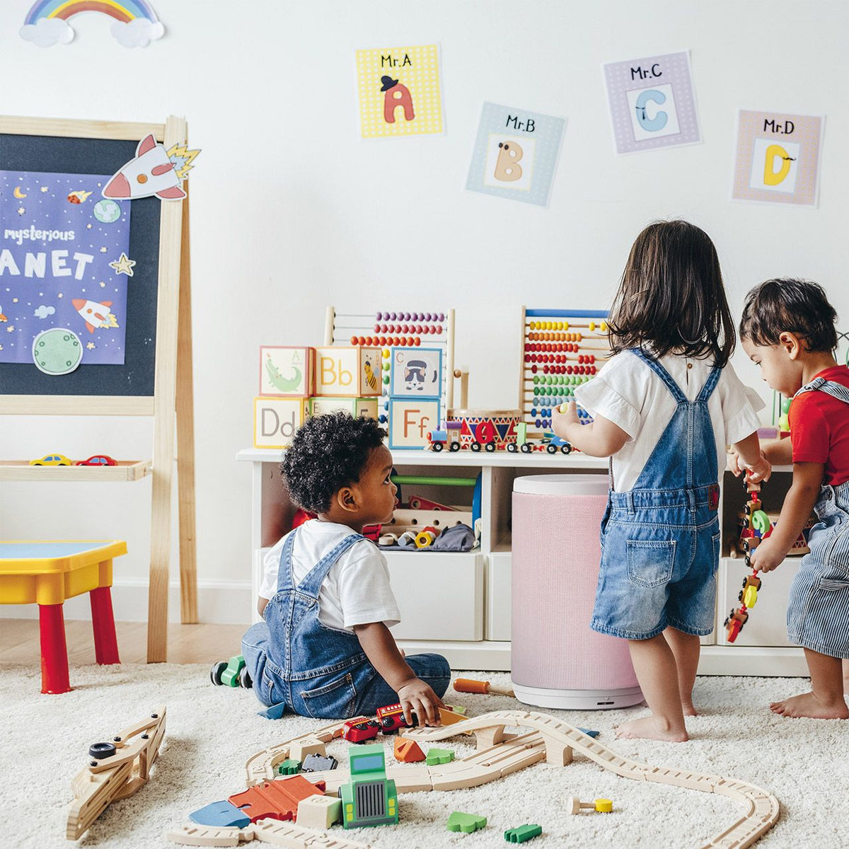 Aeris aair LITE Luftreiniger in Quartz Pink in einem Kinderzimmer mit spielenden Kindern