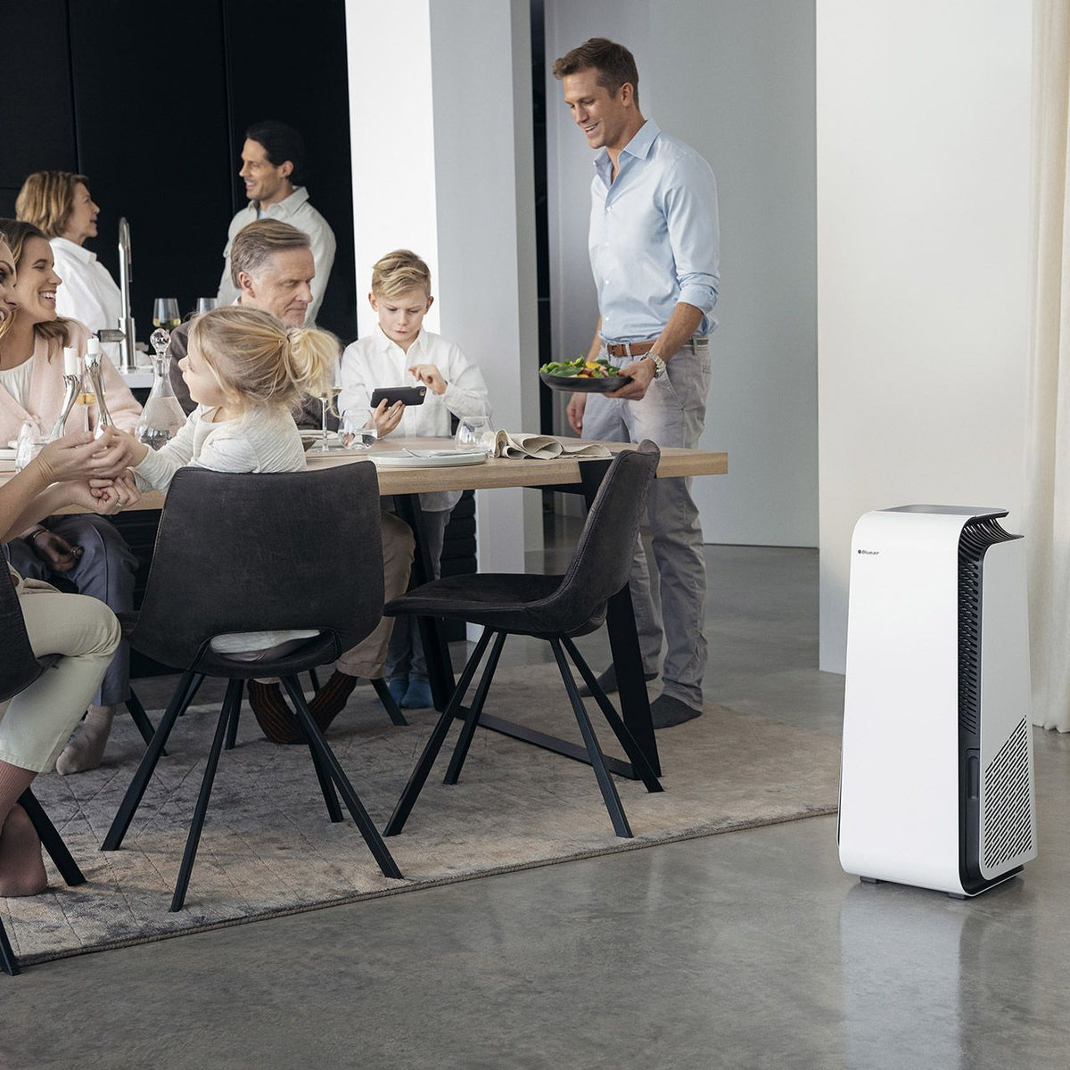 Blueair HealthProtect 7740i Luftreiniger, weiß, neben Esstisch mit Familie im Wohnbereich