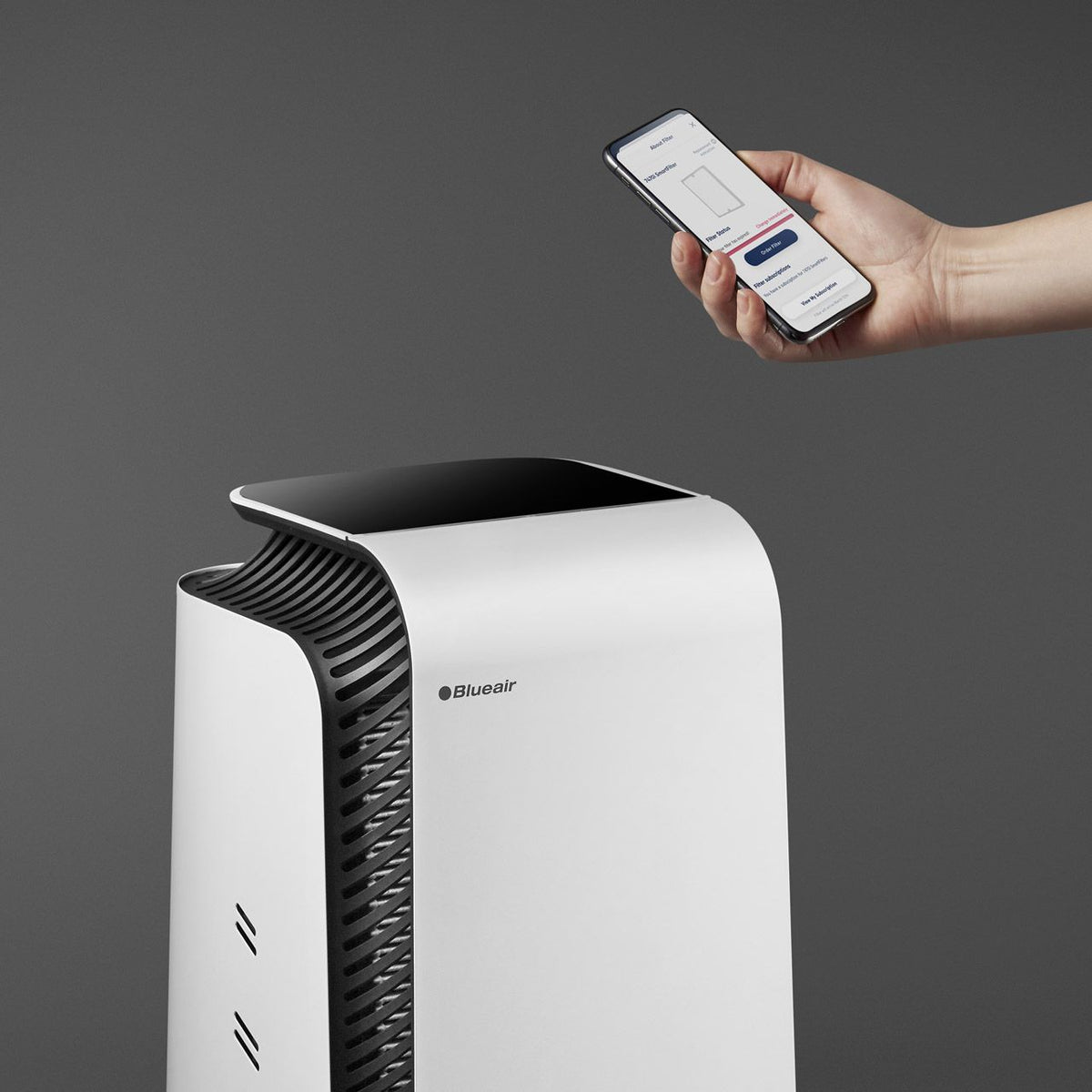 Blueair HealthProtect 7740i Luftreiniger in Weiß, Hand hält Smartphone mit Blueair-App zur Steuerung